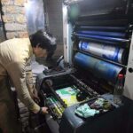 Worker busy in printing different political parties posters at his workplace in Mohallah Jangi in connection with upcoming General Elections-2024.