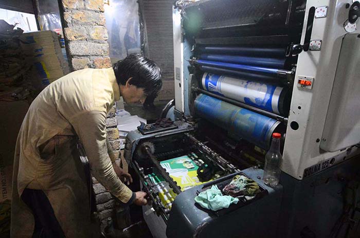 Worker busy in printing different political parties posters at his workplace in Mohallah Jangi in connection with upcoming General Elections-2024.