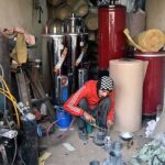 A worker busy in making gas geyser at his workplace.