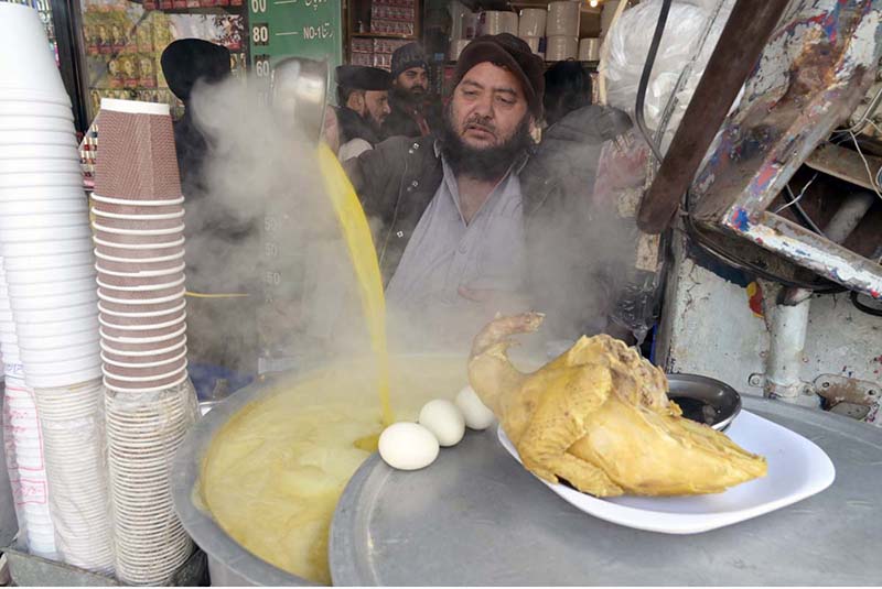 A vendor displaying chicken yakhni to attract the customers at his roadside setup during winter season in Federal Capital