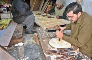 Artisans busy in carving different designs on wooden door in workshop at Saidpur Road. 