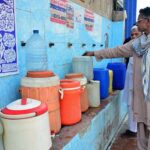 People filling their pots with clean water from water filtration plant.