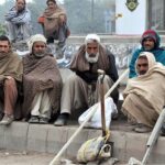 Labourers alongwith their tools sitting on roadside waiting for clients to be hired for work during morning time at KhannaPul.