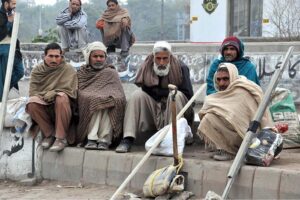 Labourers alongwith their tools sitting on roadside waiting for clients to be hired for work during morning time at KhannaPul
