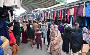 Customers selecting and purchasing old clothes displayed by the Weekly Bazaar vendors to attract the customers