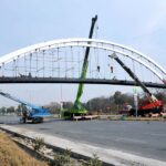 CDA workers busy installing pedestrian bridge with the help of cranes at Srinagar Highway in the Federal Capital