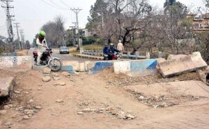  A view of damaged road being blocked at I-9 area creating problems for people and needs the attention of concerned authorities.