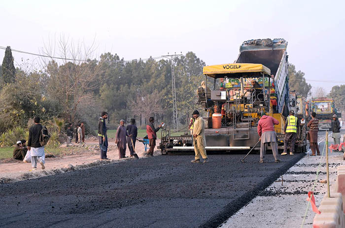 Labourers busy in construction work of Park Road with the help of heavy machineries during development work in the city.