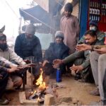 People are setting around fire during cold weather in the city