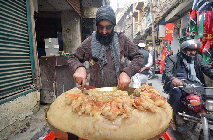 Vendor displaying traditional food item locally called "Mukhadi Halwa" to attract the customers at Qissa Khawani area