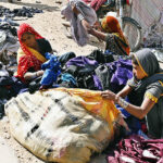 Labourer women busy in arranging and sorting old clothes at SITE area