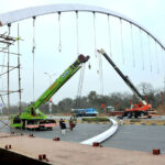 CDA workers busy installing pedestrian bridge with the help of cranes at Srinagar Highway in the Federal Capital