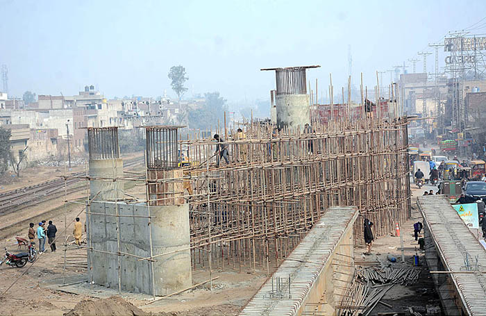 Labourers busy in construction work of flyover bridge on Jhumra Road near Abdullahpur.