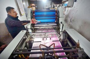 Worker busy in printing different political parties posters at his workplace in Mohallah Jhangi in connection with upcoming general elections.