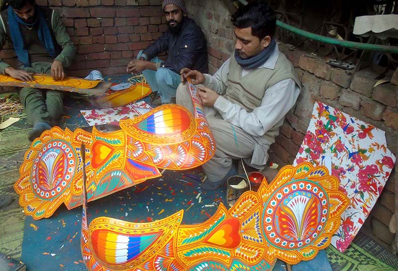 Workers busy making transport bus decoration items at their workplace
