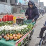 A vendor selling carrots and radish to customer at roadside setup