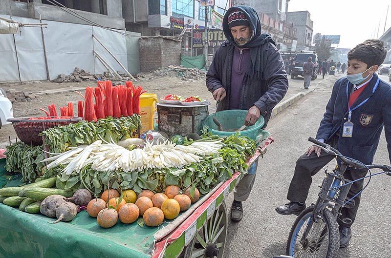 A vendor selling carrots and radish to customer at roadside setup