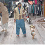 A juggler showing pet monkey tricks to earn for livelihood.