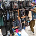 Customers selecting and purchasing old clothes displayed by the Weekly Bazaar vendors to attract the customers