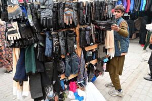 Customers selecting and purchasing old clothes displayed by the Weekly Bazaar vendors to attract the customers
