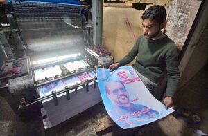 Worker busy in printing different political parties posters at his workplace in Mohallah Jhangi in connection with upcoming general elections.