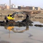 Labourer busy in collecting sand from Rice Canal using machine