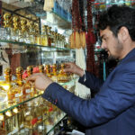 A shopkeeper arranging and displaying perfumes to attract the customers at his shop in the Federal Capital