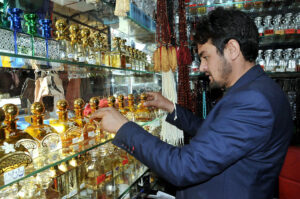 A shopkeeper arranging and displaying perfumes to attract the customers at his shop in the Federal Capital
