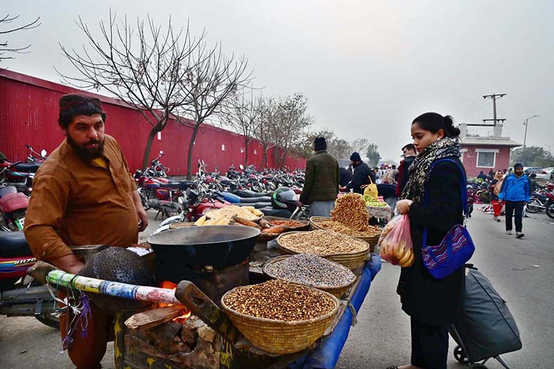 A vendor selling roasted corn to attract the customers outside Weekly Bazaar