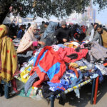 People selecting and purchasing old warm clothes from vendor at Hussain Agahi