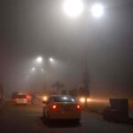 Vehicles on their way during thick fog that engulf the city.