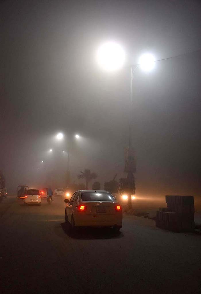 Vehicles on their way during thick fog that engulf the city.