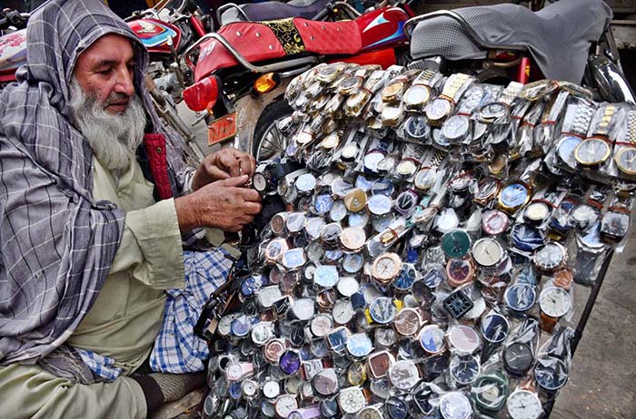 A vendor displaying different kind of wrist watches to attract the customers at Jinnah Bagh Chowk