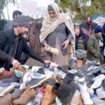Vendor selling and displaying second hand shoes to attract the customers at Faqirabad area during his roadside setup.