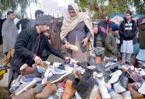 Vendor selling and displaying second hand shoes to attract the customers at Faqirabad area during his roadside setup.