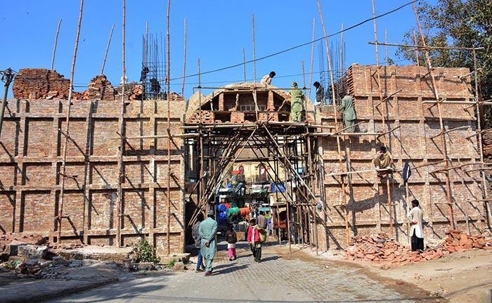 Labourers busy in construction work of historical heritage Pakka Fort in the city.