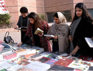 People selecting books from a Book Fair at Al-Hamra