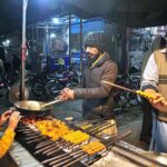 Vendor busy in preparing traditional food items “seekh kabab” and “tikka” for customers at Azadi Chowk.