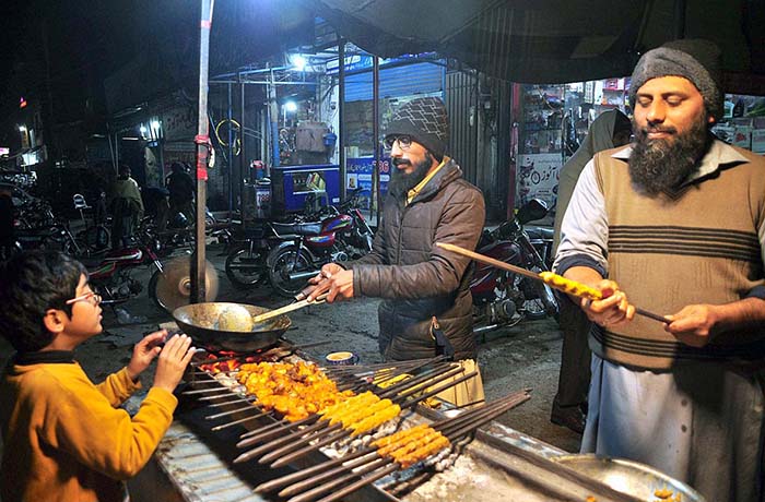 Vendor busy in preparing traditional food items “seekh kabab” and “tikka” for customers at Azadi Chowk.