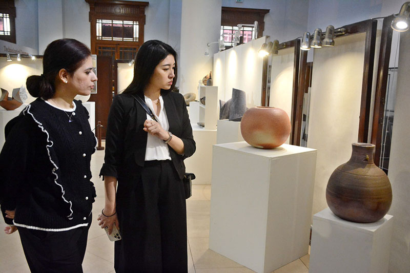 Visitors watching traditional pottery and ceramic pieces displayed in Exhibition 'Yakishime, Earth Metamorphosis' at SBP Museum