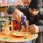 A shopkeeper is decorating various items used for mehndi functions at his shop to attract the customers at Fawara Chowk.