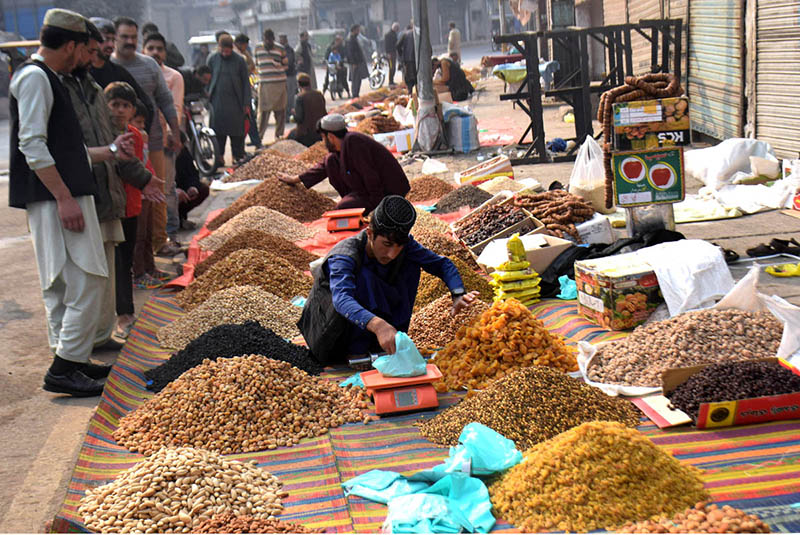 People are busy purchasing dry fruits from roadside vendor People are busy purchasing dry fruits from roadside vendor