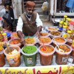 A vendor displaying various pickles to attract the customers at Resham Gali.