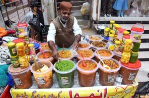 A vendor displaying various pickles to attract the customers at Resham Gali. 