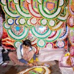 A vendor preparing the money garlands for wedding at his workplace