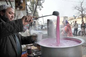 A vendor making and selling Kashmiri tea at his roadside setup at Aabpara Market in Federal Capital.