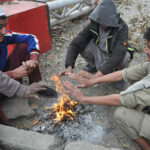 People are sitting around fire, warm themselves as the temperature dropped in Federal Capital