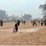 Youngsters playing cricket in a local ground near Expressway