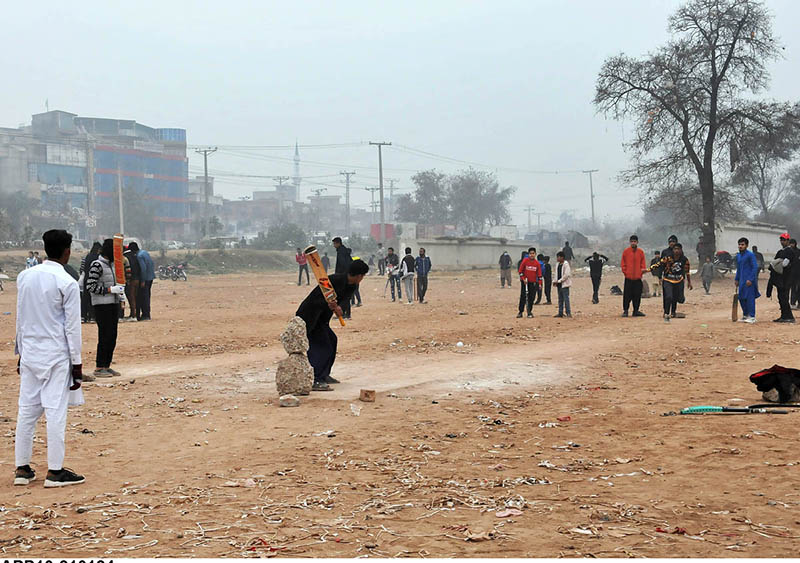Youngsters playing cricket in a local ground near Expressway