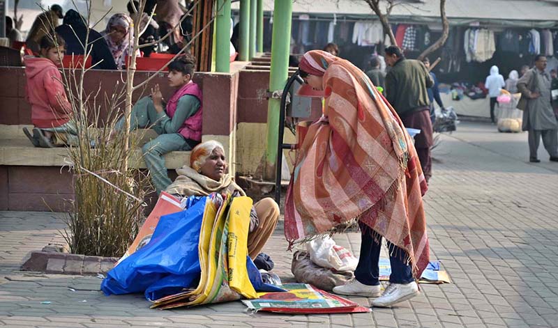 An elderly woman vendor selling shopping bags at Weekly Bazaar in Federal Capital